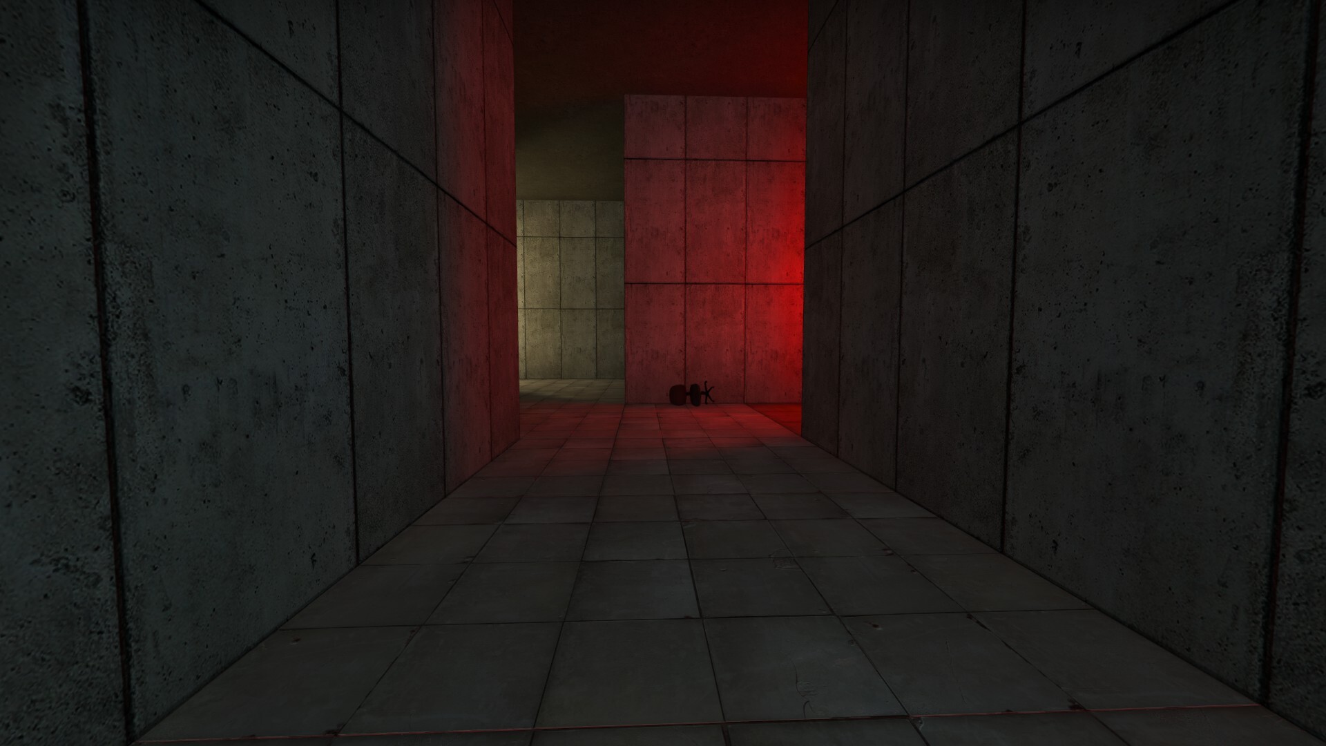 An ominous concrete hallway with a tipped over chair illuminated by an off screen red light.